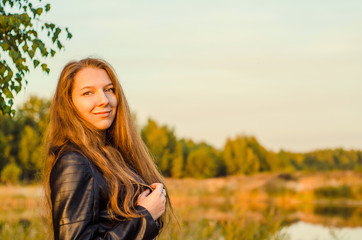 Beautiful girl in a posh red dress posing on a poppy field. Poppy field at sunset. Art processing. Sunset