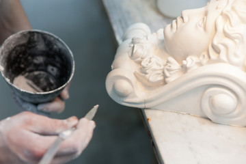 Ein Stukkateur restauriert eine Stuck Figur