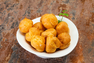 Sweet tasty profiteroles heap in the bowl