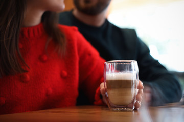 Lovely couple with fresh aromatic coffee at table in cafe, closeup