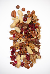 Mixed nuts and dried fruits in wooden bowl on white background, copy space
