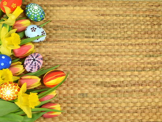 Happy Easter - painted eggs and daffodils on colored background