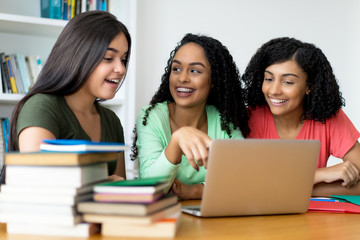 Lachende junge Azubis bei der Arbeit am Computer