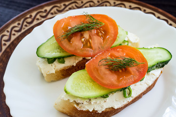Sandwich with cream cheese, tomatoes and spicy herbs. The concept of diet food. Low calorie breakfast. Close-up.