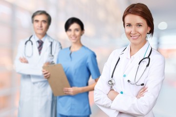 Attractive young female doctor on medical team background