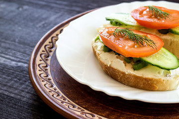 Sandwich with cream cheese, tomatoes and spicy herbs. The concept of diet food. Low calorie breakfast. Close-up.