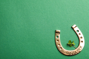 Flat lay composition with horseshoe on green background, space for text. St. Patrick's Day...
