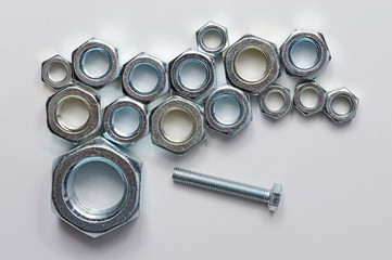 New chrome screw-nut of different sizes on a white background. Concept.
