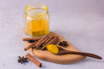 Ingredients for the preparation of golden milk - turmeric, cinnamon on a gray background