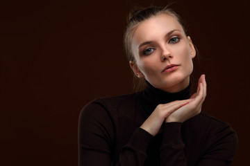 Beautiful girl in a maroon turtleneck on a brown background