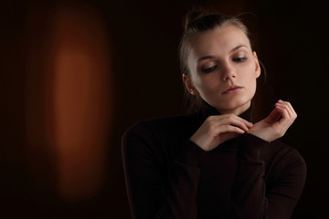Beautiful girl in a maroon turtleneck on a brown background