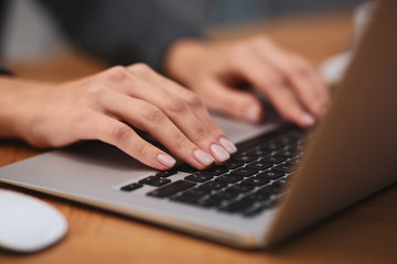 Woman working on modern laptop at table, closeup