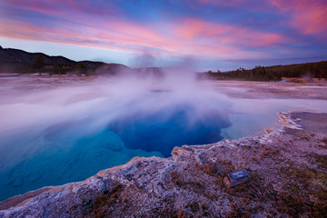 Sapphire Pool in Biscuit basin with blue steamy water and beautiful colorful sunset. Yellowstone, Wyoming, USA