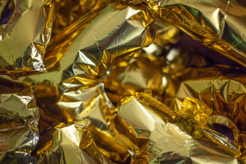 Golden inflatable balloon letters scattered in a pile