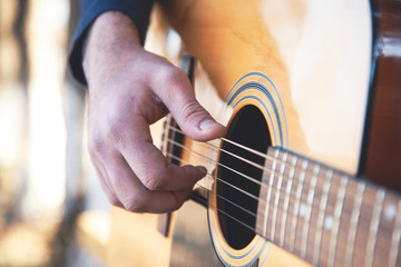Fototapeta premium Young man plays guitar outdoors