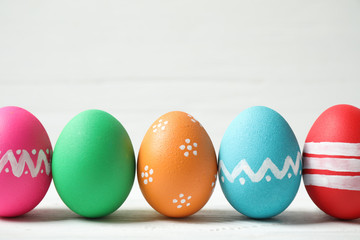 Colorful Easter eggs on white wooden background. Space for text