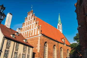 Fototapeta premium St John Church in Old Town of Riga, Latvia. Aged Latvian lutheran Church under blue sky