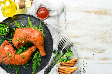 Smoked chicken thighs with ketchup on a black stone plate. Top view. Free space for text.