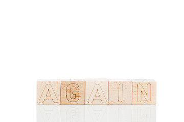 Wooden cubes with word again on a white background