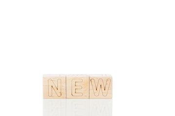 Wooden cubes with word new on a white background