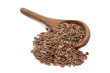 Linseeds or flax seed on a tilted brown wooden spoon with spill seen obliquely from front and above isolated on white background