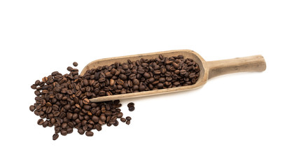 Roasted coffee beans on a large wood scoop in slanted view from above and isolated on white background