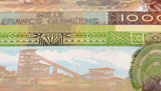 Guinea franc banknotes slow tracking. Guinean currency. Slider shot, low angle. 4K