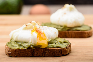 Sandwiches with poached egg and avocado paste on cereal bread.