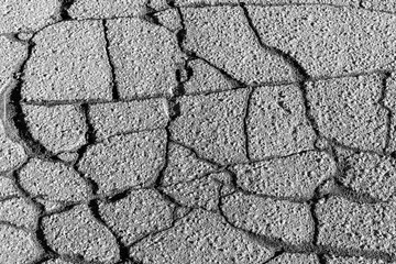 Texture of gray cracked asphalt. Abstract backdrop for design.