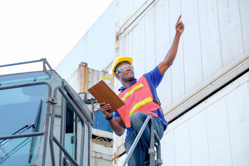 African technician worker stand on big truck and point to some direction with concept go to the way of successful.