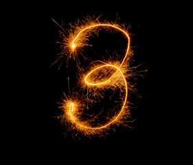 number three written with a sparkler on a black background