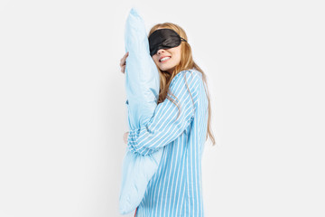 Obraz premium Portrait of beautiful cute sleeping girl in pajamas hugging pillow sleeping on white background