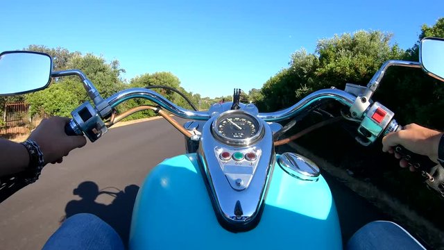 Motorcycle ride on a winding coastal road at sunset. Sardinia, Italy