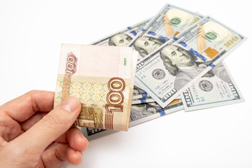 A hand holding one hundred ruble and american dollar banknotes on background, ruble devaluation and usd-rub exchange rate concept