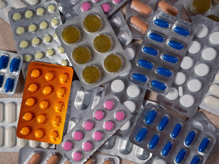 Various medical preparations make up a colorful background. Tablets and capsules in plastic blisters. Medical education.