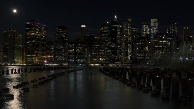 Full moon set over Financial District from Broken pier on East river night to day time lapse