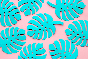 Monstera leaves made of paper on a pink background with space for text.