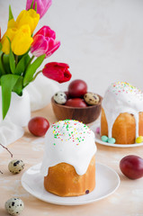 Obraz na płótnie Canvas Easter composition. Easter Cake - Russian and Ukrainian Traditional Kulich with easter eggs on a light stone background. Paska Easter Bread. Selective focus. Vertical orientation. Copy space