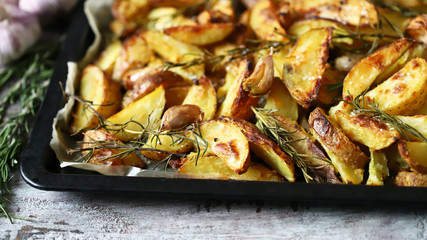 Rustic golden baked potato. Sliced baked potato with spices, garlic and rosemary. Vegan lunch. Christmas dish. Macro.