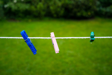 Laundry clip at Rain on wet clothesline outside in the garden