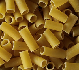 Uncooked smooth short tubes shape pasta also known as tubetti lisci background and texture