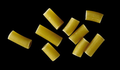 Uncooked smooth short tubes shape pasta also known as tubetti lisci isolated on black background, top view and clipping path