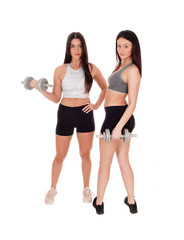 Two woman exercising with dumbbells in the studio