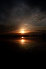 Fototapeta na wymiar sunset over the river in a dark key