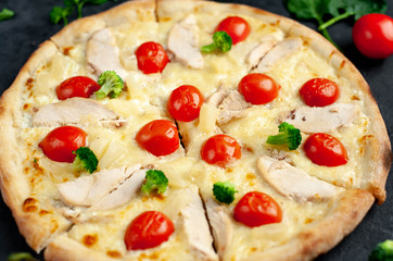 delicious pizza with pineapple, broccoli, tomatoes, mozzarella cheese, chicken fillet on a stone background