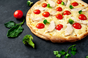 delicious pizza with pineapple, broccoli, tomatoes, mozzarella cheese, chicken fillet on a stone background