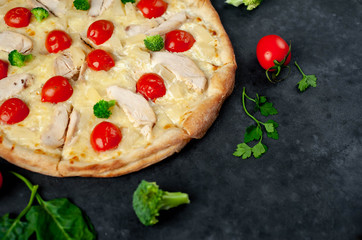delicious pizza with pineapple, broccoli, tomatoes, mozzarella cheese, chicken fillet on a stone background with copy space for your text