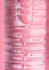 Water bottle on pink background close-up