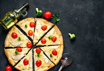delicious pizza with pineapple, broccoli, tomatoes, mozzarella cheese, chicken fillet on a stone background with copy space for your text