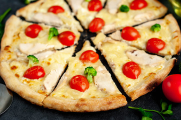 delicious pizza with pineapple, broccoli, tomatoes, mozzarella cheese, chicken fillet on a stone background